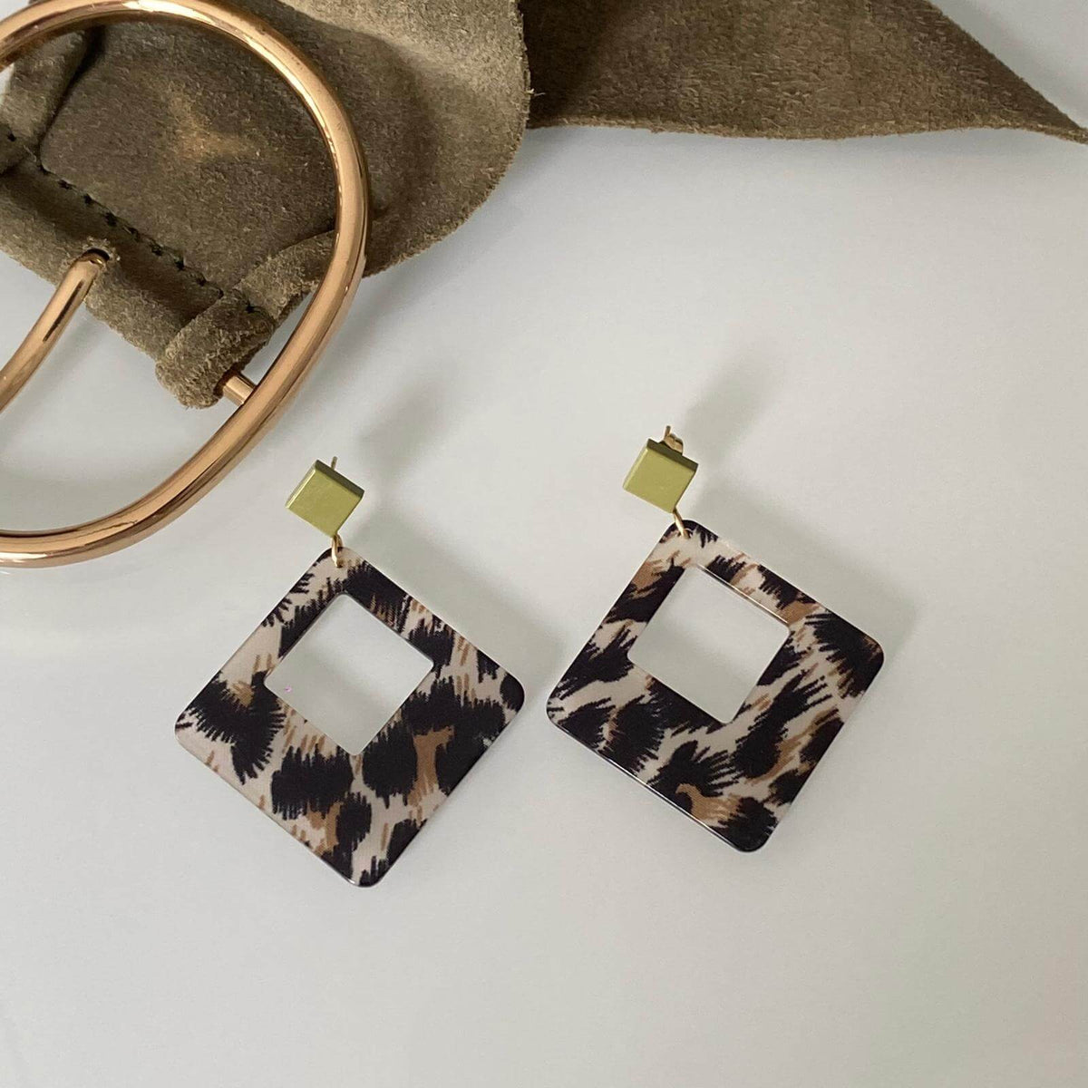 Boucles d'oreilles Léopard en acétate carré avec un motif animalier et des détails dorés.