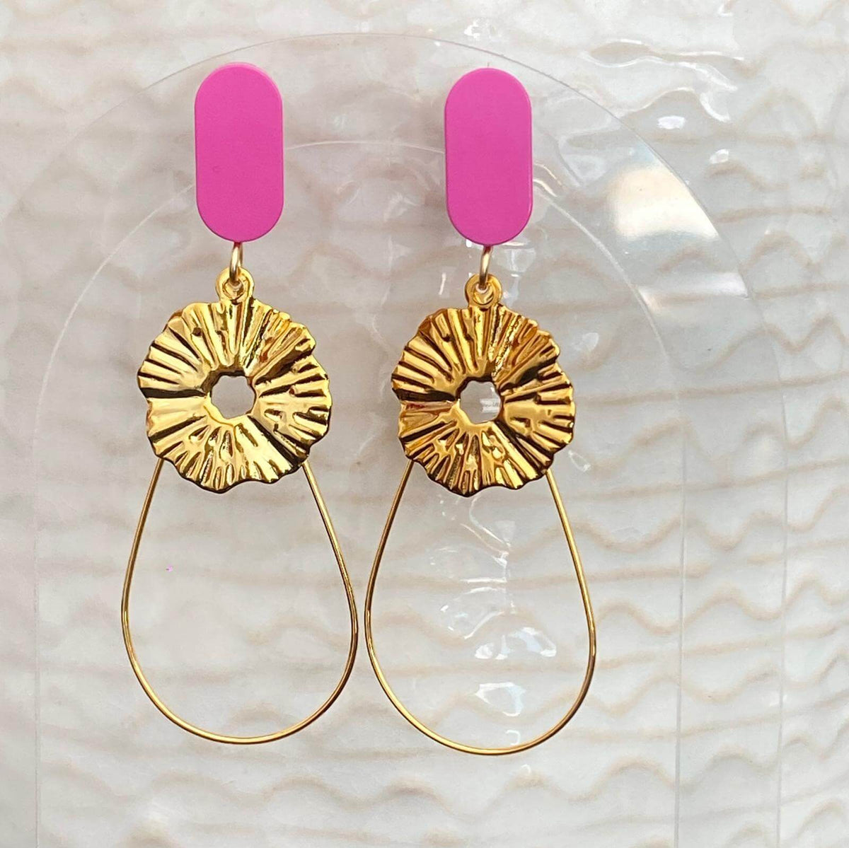 Boucles d'oreilles raffinées avec une brique tuile de Lego ovale à l'oreille associée avec une fine goutte et une pièce dorée comme un soleil suspendu. Le Lego apporte la touche de couleur à ce bijou fantaisie.