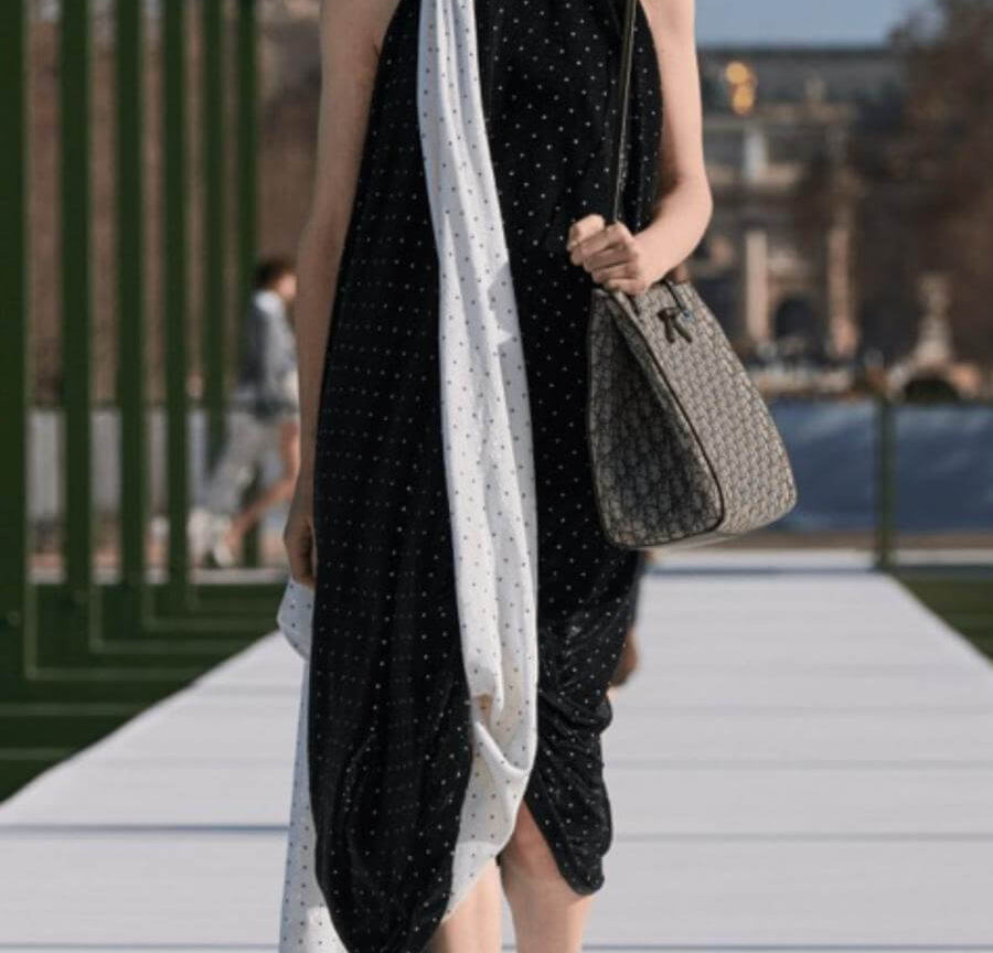 Full tendance pois noirs et blancs avec ces boucles d'oreilles assorties à la robe et aux accessoires portés par une femme élégante dans la rue