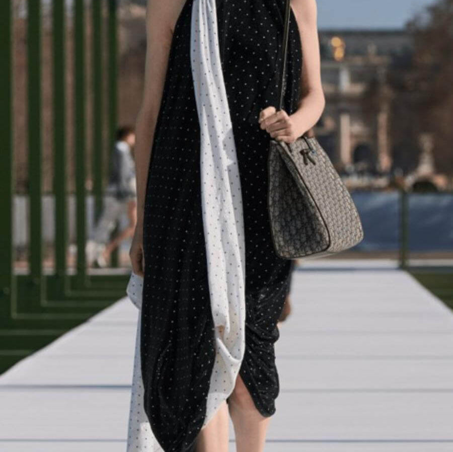 Full tendance pois noirs et blancs avec ces boucles d'oreilles assorties à la robe et aux accessoires portés par une femme élégante dans la rue