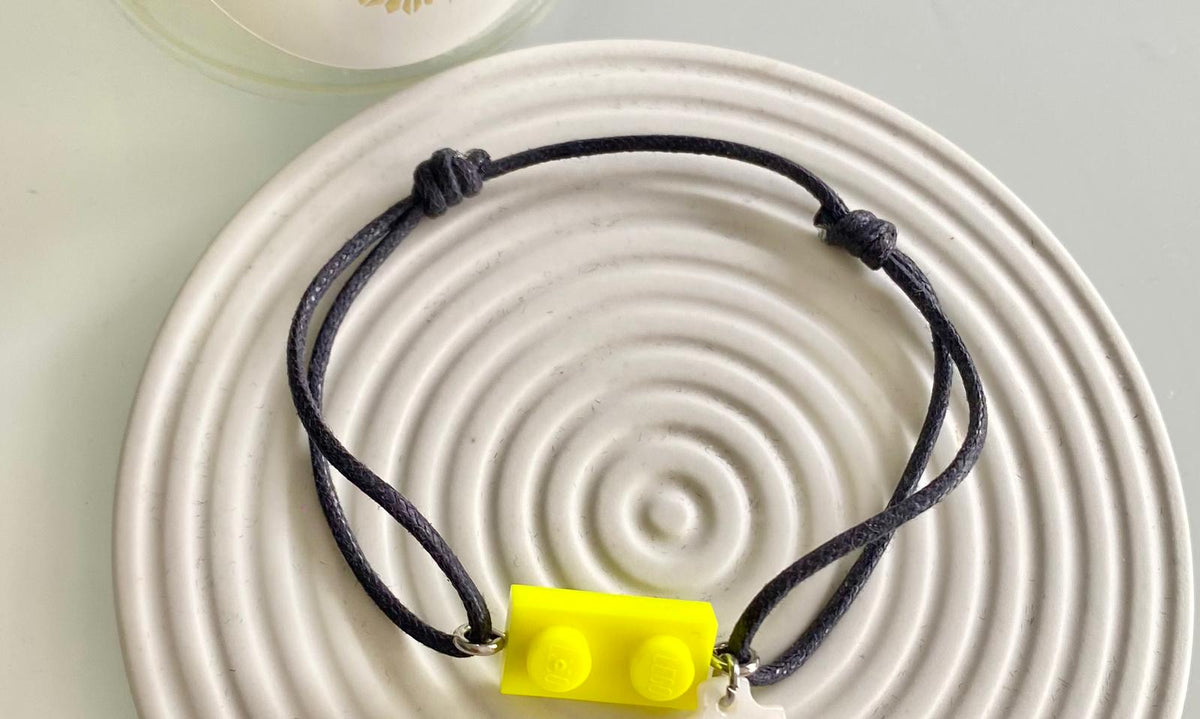 Bracelet mixte garçon ou fille à offrir en cadeau de 1ère Communion ou profession de Foi avec une brique de Lego jaune fluo authentique et une croix nacrée. Un cadeau pas cher à moins de 15€.