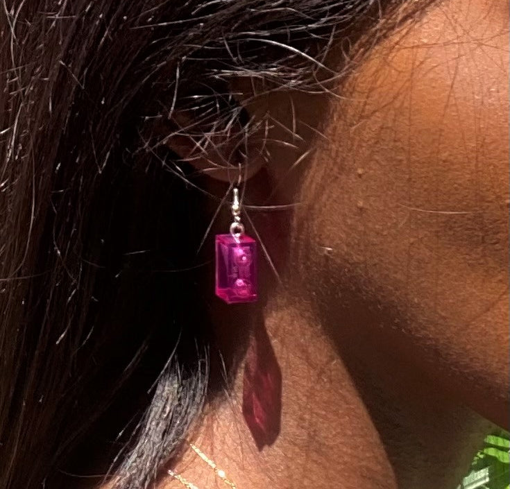 Boucles d'oreilles pendantes argentées avec briques Lego® roses, ajoutant une touche colorée à votre look.