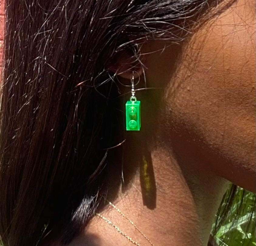 Boucles d'oreilles pendantes vertes en Lego, ajoutant une touche fun à votre look, avec une brique de 1x2 cm.
