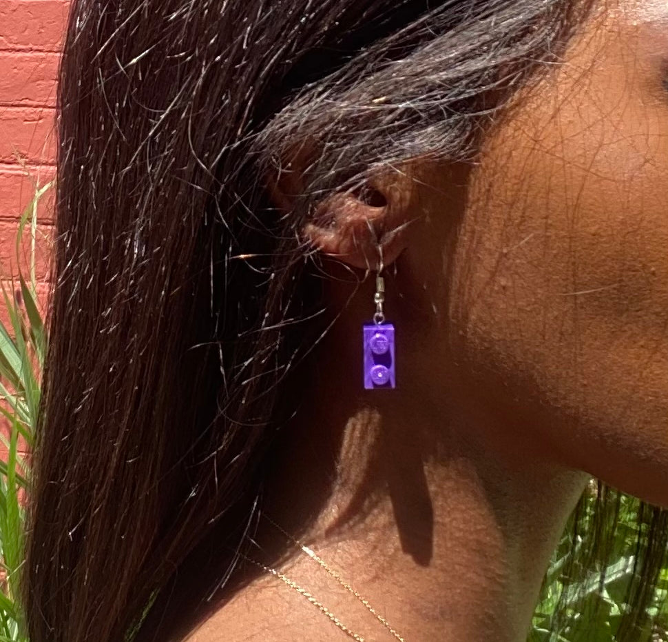 Boucles d'oreilles pendantes argentées avec brique Lego® violette, ajoutant une touche colorée à votre look.