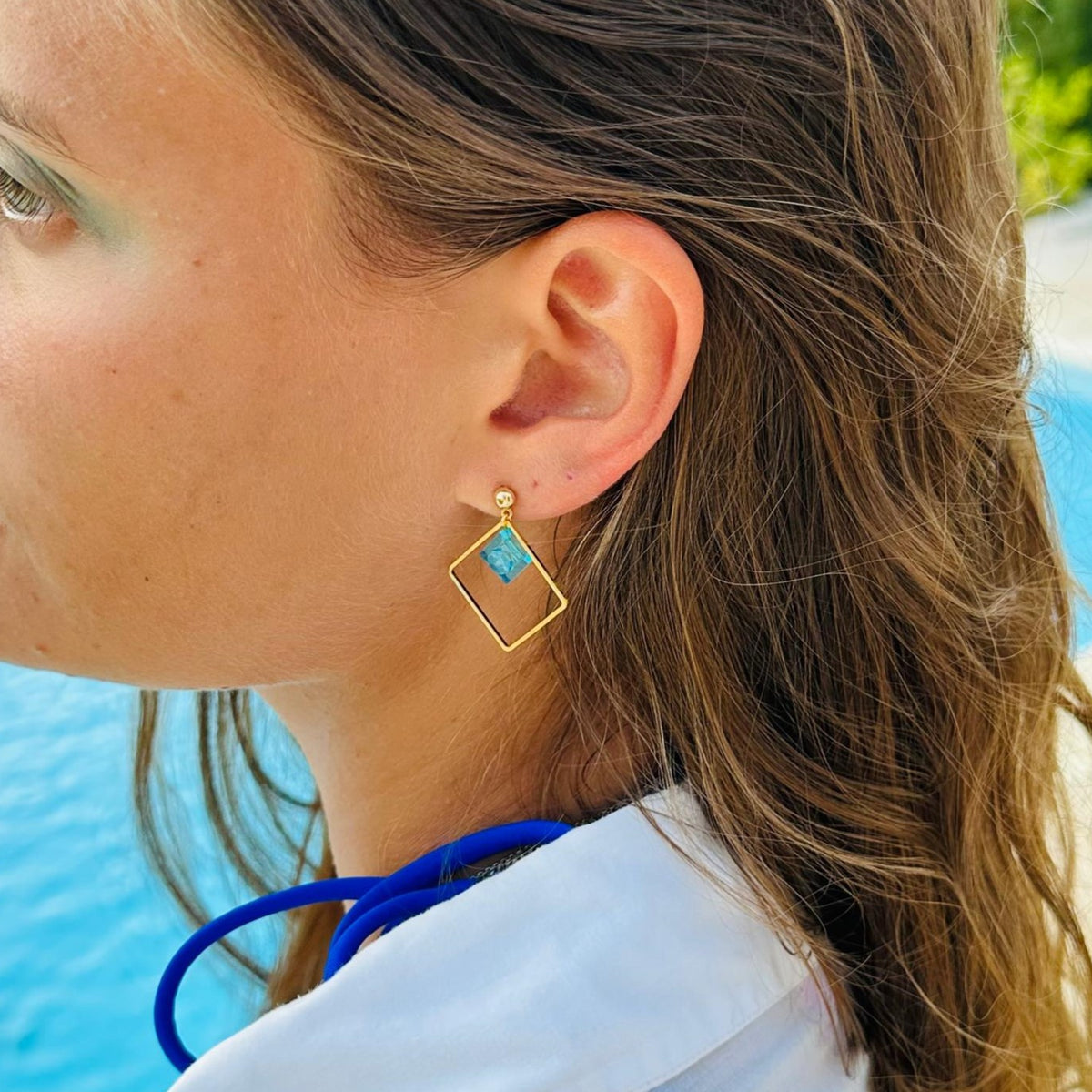 Boucles d'oreilles pendantes colorées avec un Lego. Un bijou fantaisie décliné dans de nombreux coloris de brique Lego 1x1 bleu clair transparent, rose, jaune, vert,...