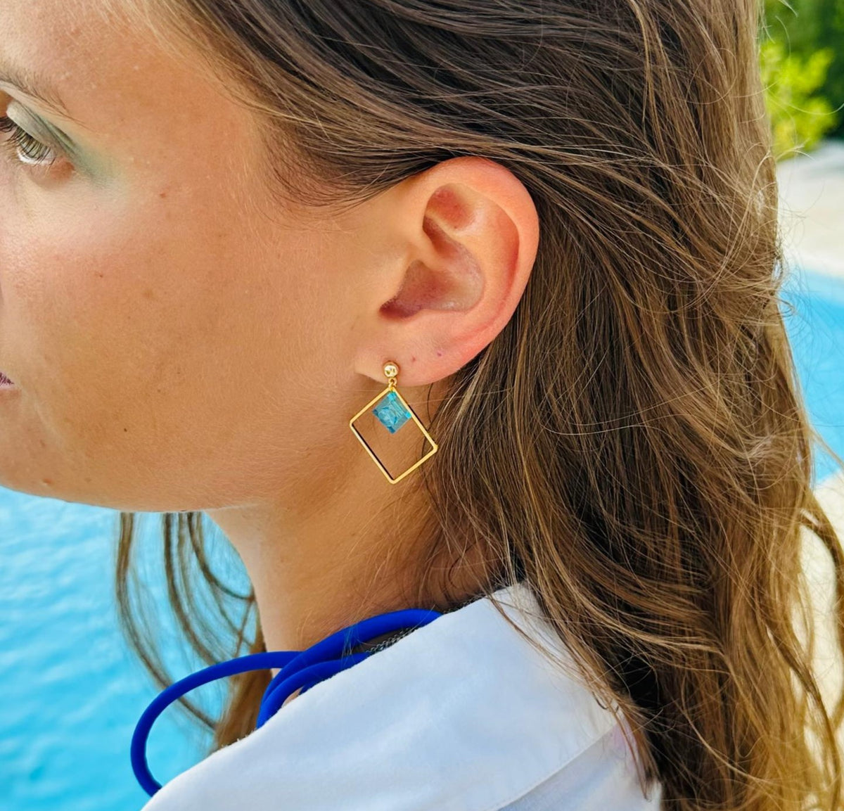 Boucles d'oreilles pendantes colorées avec un Lego. Un bijou fantaisie décliné dans de nombreux coloris de brique Lego 1x1 bleu clair transparent, rose, jaune, vert,...