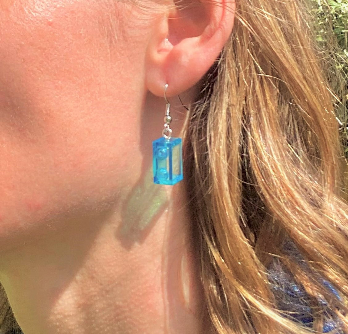 Boucles d'oreilles pendantes en Lego® bleu, ajoutant une touche colorée et amusante à votre look. Fabriquées avec des briques Lego.