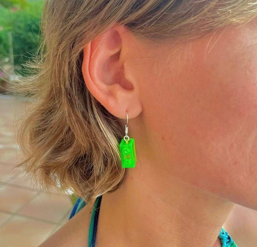 Boucles d'oreilles pendantes avec une brique Lego verte translucide effet fluo, la touche de couleur ludique pour un look original et unique.