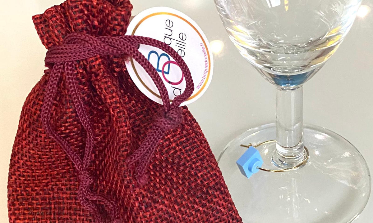 Marque-verres en acier inox avec un sachet rouge, idéal pour soirées nombreuses et bijoux pour les verres à pieds.