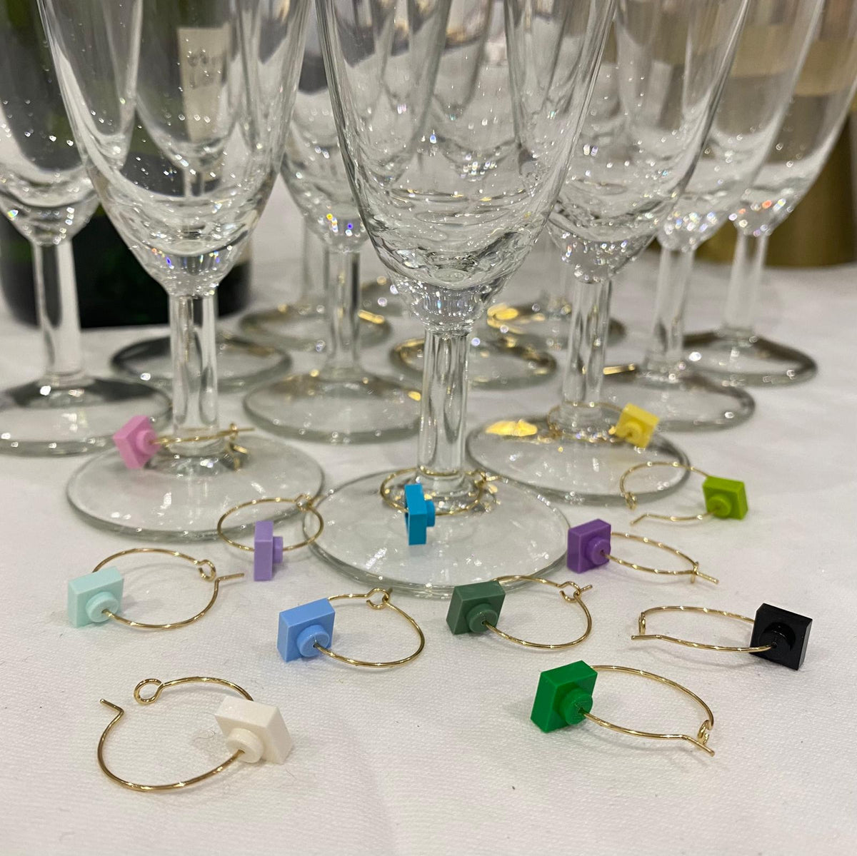 Marque-verres en acier inox avec des briques Lego colorées, idéaux pour soirées nombreuses.