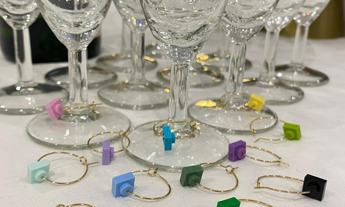 Marque-verres en acier inox avec des briques Lego colorées, idéaux pour soirées nombreuses.