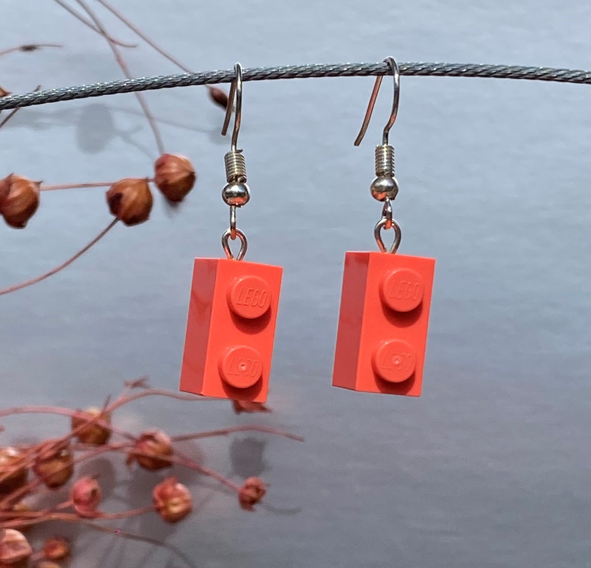 Boucles d'oreilles pendantes en brique Lego® rose corail pour un look coloré et moderne, fabriquées avec des matériaux légers.