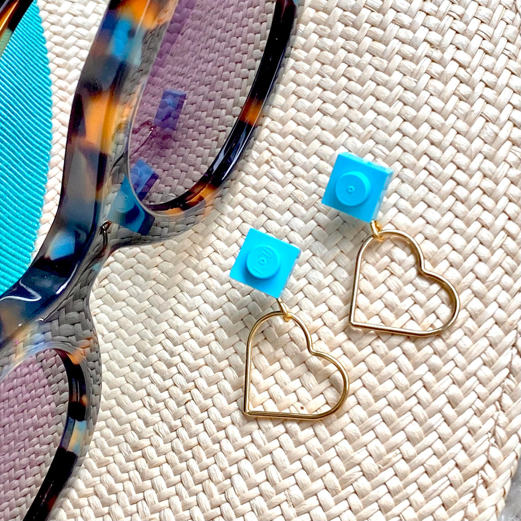 Petites boucles d'oreilles saint Valentin avec un Lego rose corail en clou d'oreille et un petit coeur doré évidé suspendu 