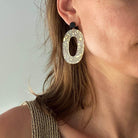 Boucles d'oreille paillettes or et Lego mettant en avant une élégante pièce ovale en acétate.