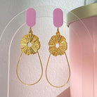 Boucles d'oreilles chic avec un Lego lisse et discret auquel est accroché une goutte en fil doré et un soleil. Un bijou raffiné aux teintes peau et rosées
