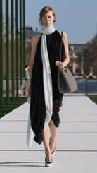 Full tendance pois noirs et blancs avec ces boucles d'oreilles assorties à la robe et aux accessoires portés par une femme élégante dans la rue