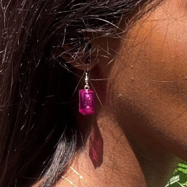 Boucles d'oreilles pendantes argentées avec briques Lego® roses, ajoutant une touche colorée à votre look.