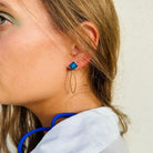 Boucle d'oreilles pendante avec un oval en laiton doré suspendue à une brique de Lego 1x1 plate bleu foncé transparent, esprit saphir. Elle se coordonne parfaitement avec les pulls, écharpes, robes bleu foncé ou bleu roi. Magnifique sur les femmes aux yeux bleus.