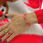 Bracelet spécial Noël avec un sucre d'orge imprimé sur une brique de Lego authentique. Le bracelet se règle avec un cordon rouge ajustable coulissant facilement. Les bagues sont vendues séparément.