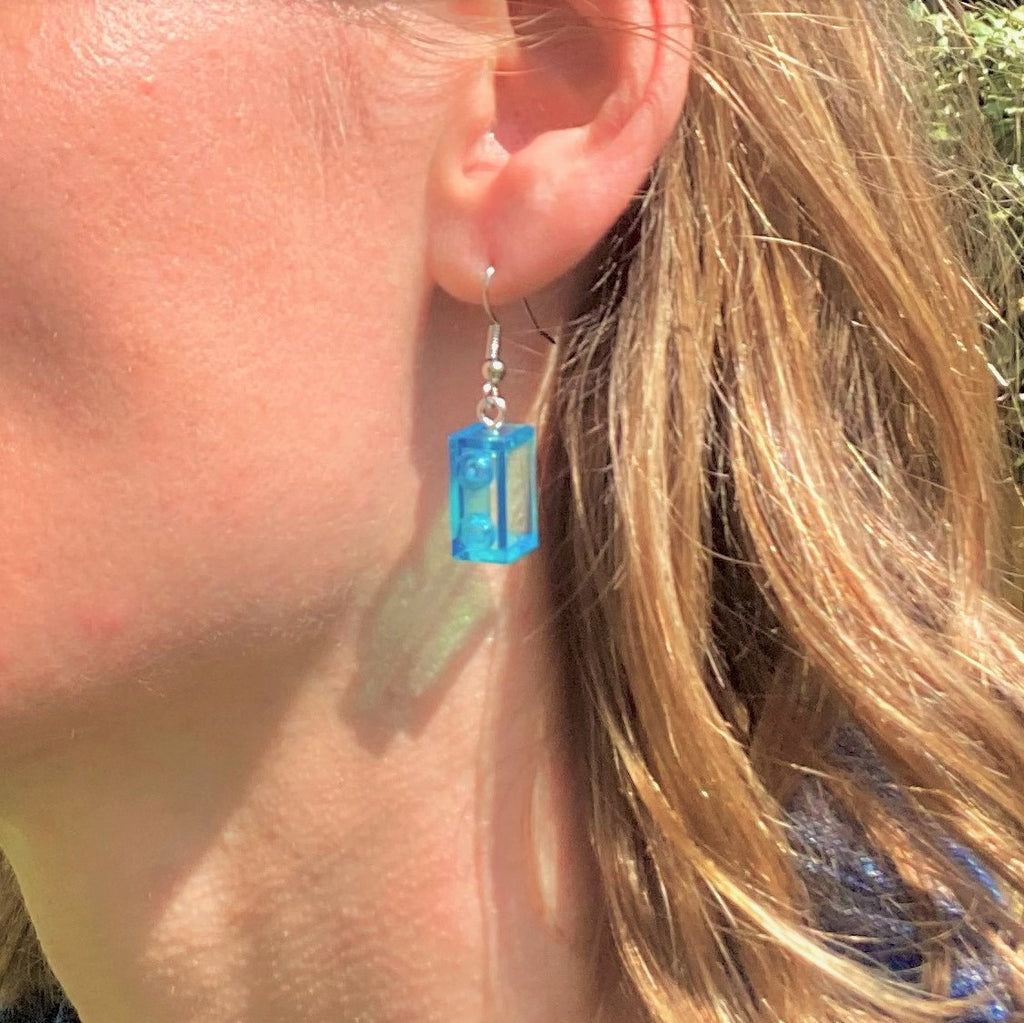 Boucles d'oreilles pendantes en Lego® bleu, ajoutant une touche colorée et amusante à votre look. Fabriquées avec des briques Lego.