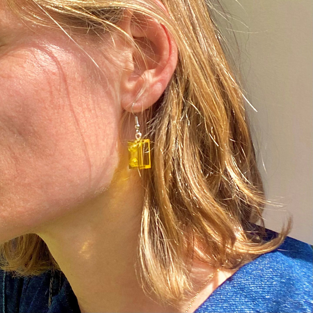 Boucles d'oreilles pendantes jaunes en Lego, apportant une touche de couleur et de style moderne.