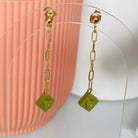 Boucles d'oreilles pendantes dorées avec brique Lego® vert kaki, chaîne légère et originale pour un look fantaisie.