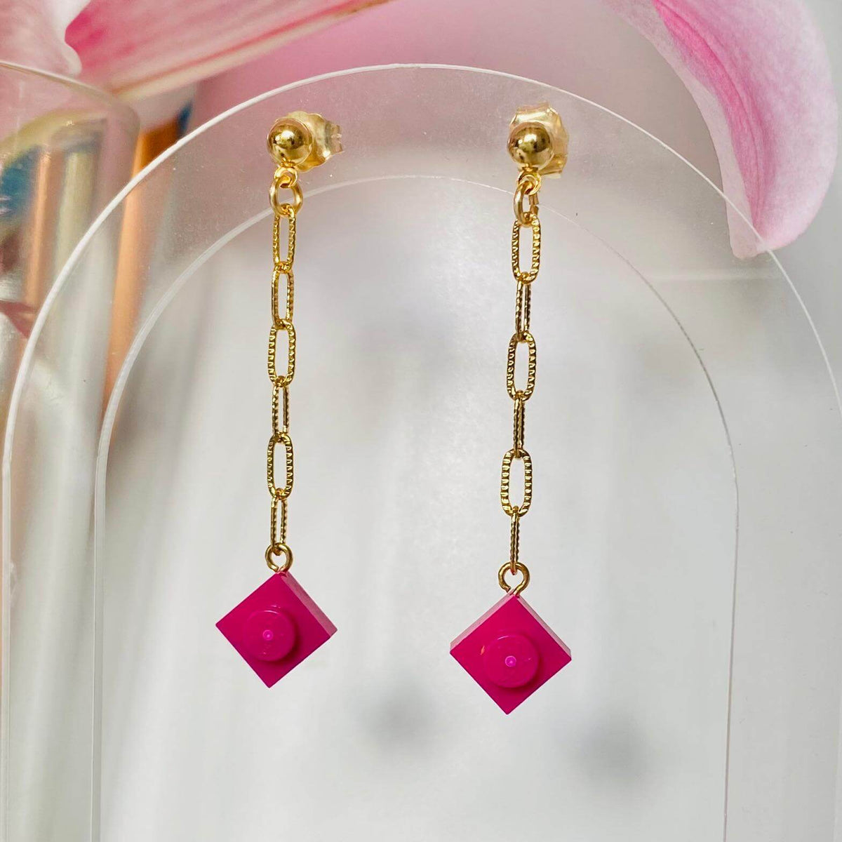 Boucles d'oreilles pendantes dorées avec briques Lego® colorées rose fuchsia, chaîne légère et originale, style fantaisie.