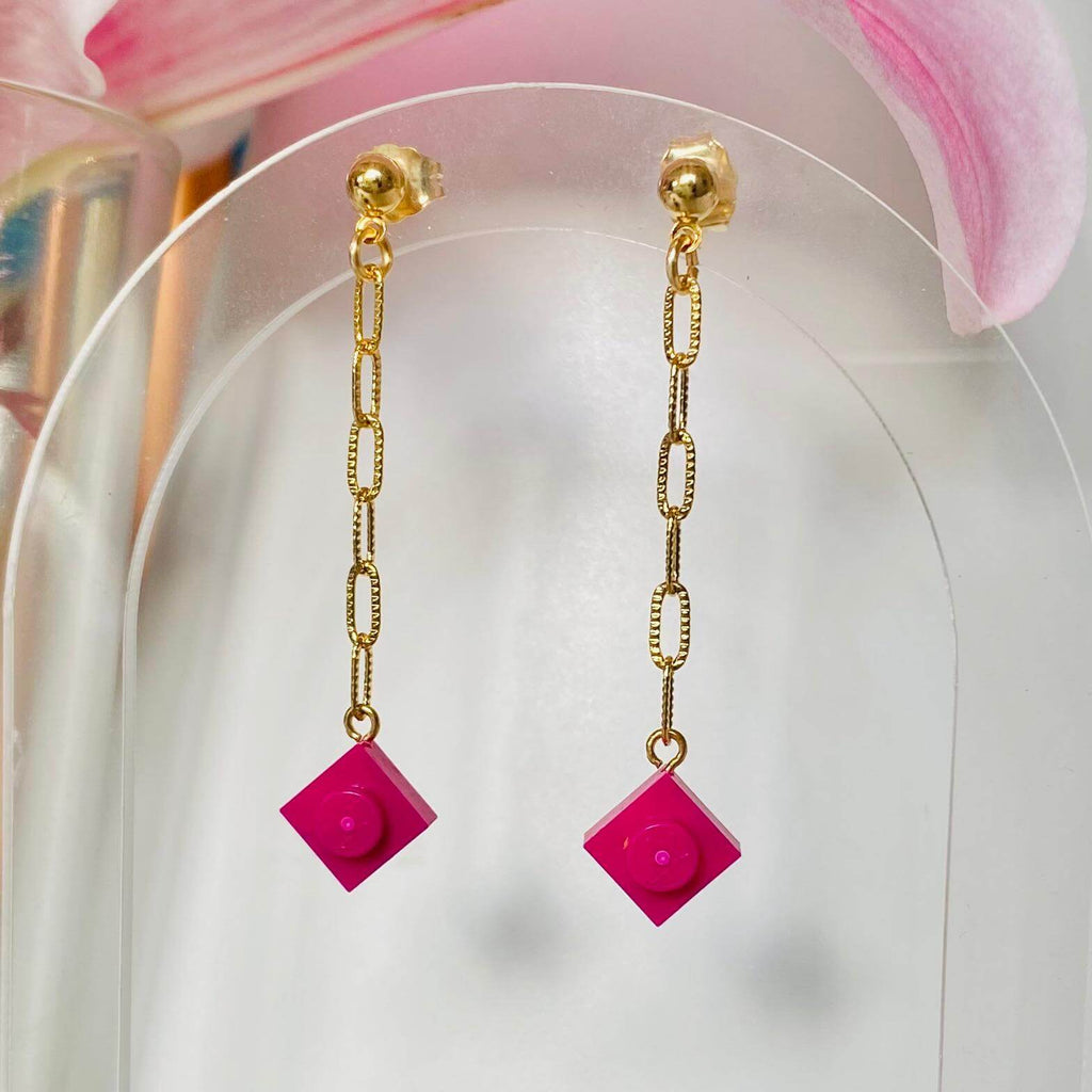 Boucles d'oreilles pendantes dorées avec briques Lego® colorées rose fuchsia, chaîne légère et originale, style fantaisie.