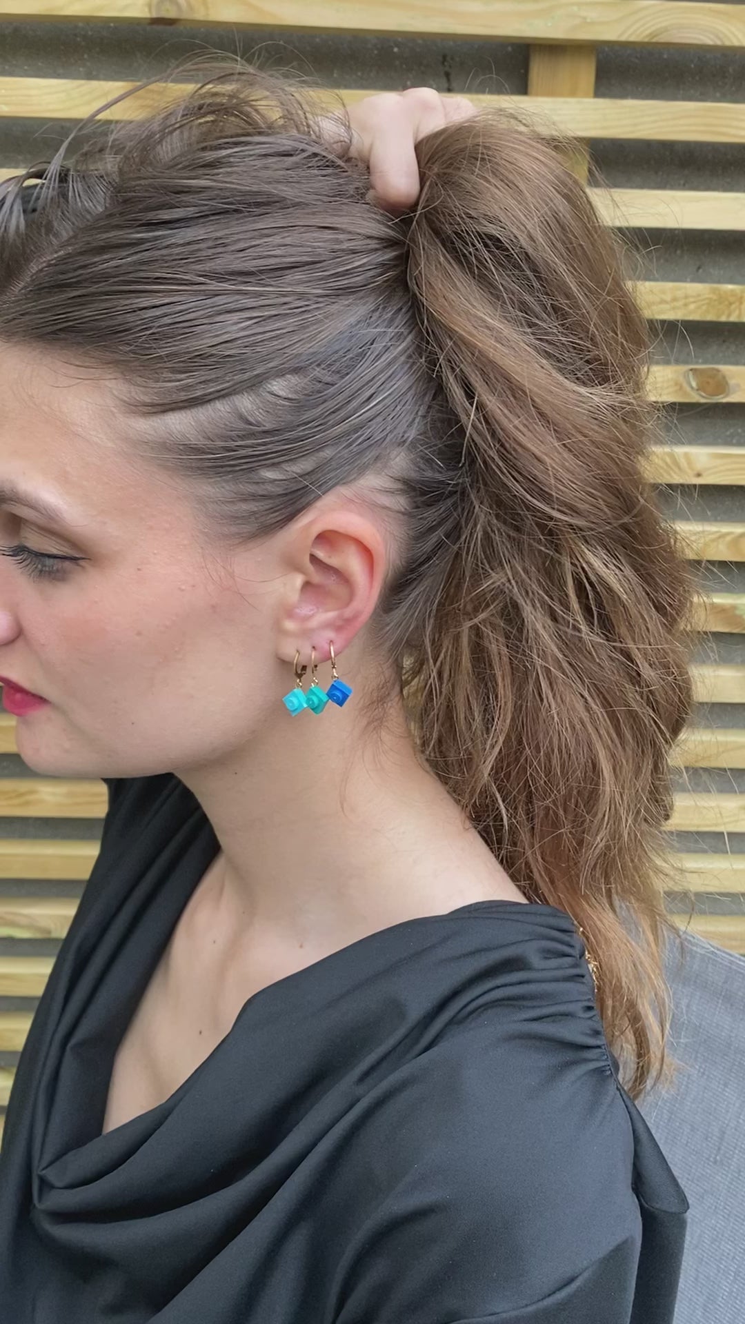Trois mini créoles, dormeuses, accumulées sur l'oreilles avec une brique Lego turquoise, une brique bleu paon et une brique bleu roipour une style fantaisie, coloré, rock, et fun!