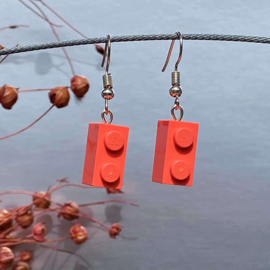 Boucles d'oreilles pendantes en brique Lego® rose corail pour un look coloré et moderne, fabriquées avec des matériaux légers.