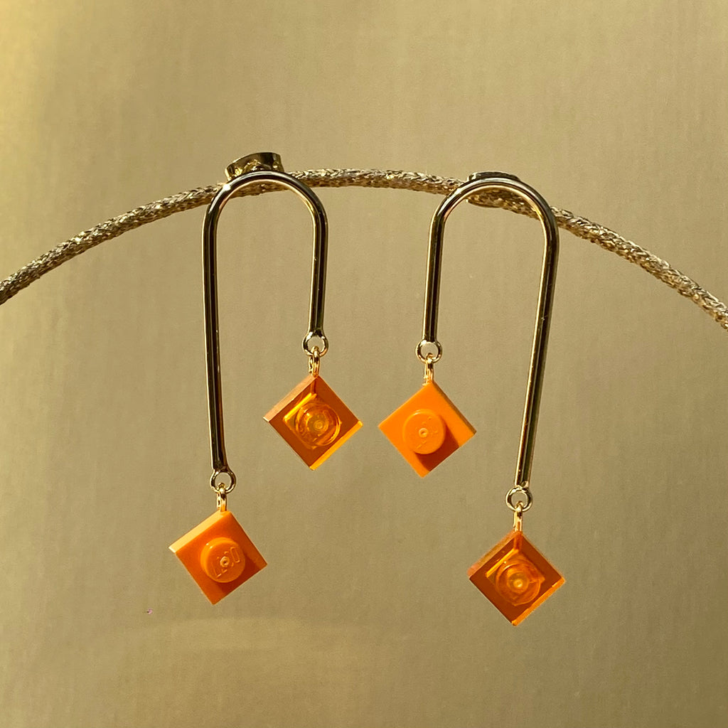 Boucles d'oreilles pendantes fashion et asymétriques avec 2 mini briques de Lego orange suspendues, inspirées de l'art déco