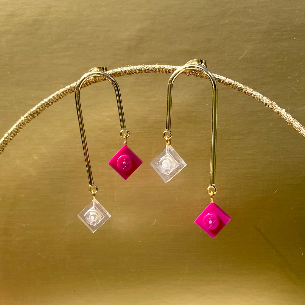 Boucles d'oreilles pendantes asymétriques en art déco avec briques en lego rose pivoine et transparents, élégantes et graphiques.